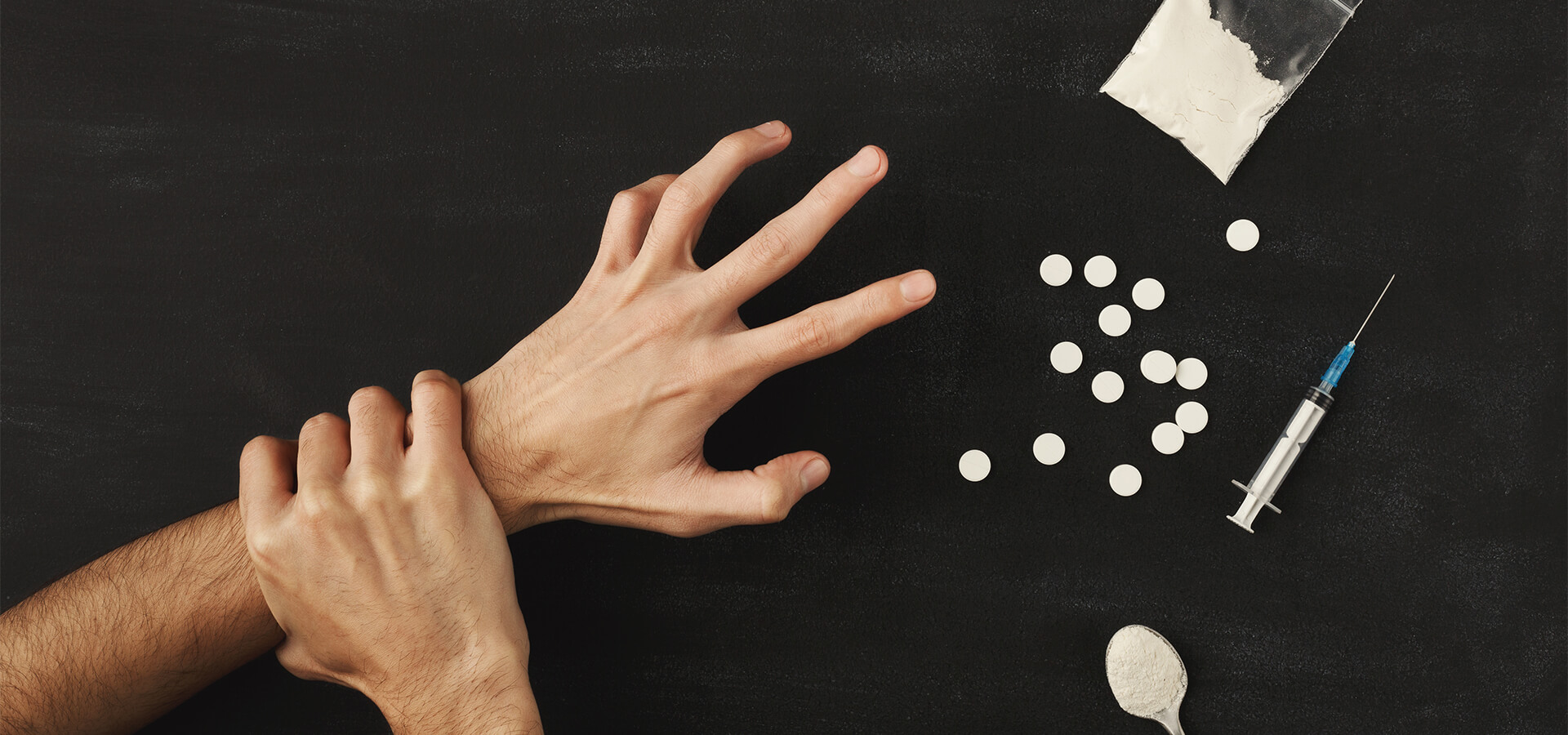 headeraddictionstop hand grabbing another hand reaching for drugs