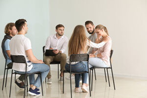 group of people in therapy at opiate addiction treatment program