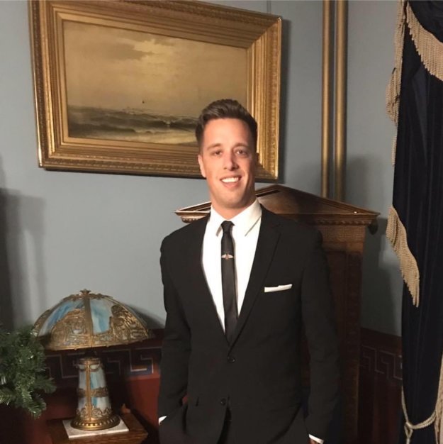 man standing by older painting