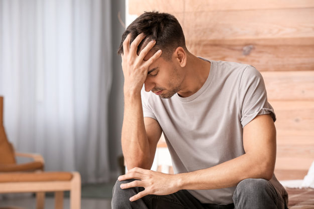 opioid abuse man holding head struggling with opioid abuse