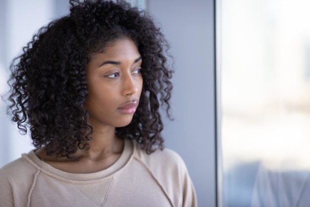 Signs of Morphine Abuse a woman looking out a window thinking about the signs of morphine abuse